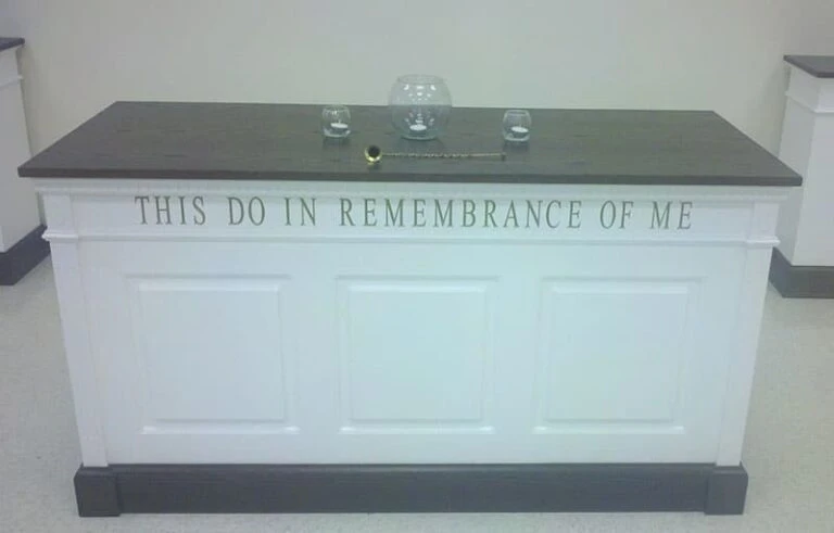 A white wall with a sign partially reading 'IN REMEMBRANCE OF'.