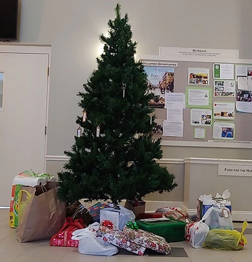 A decorated Christmas tree surrounded by wrapped gifts in a room.