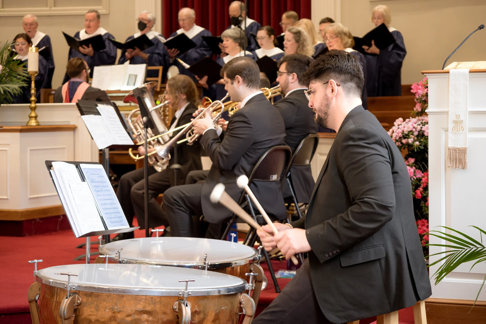 Orchestra percussionists performing with focus during a concert.