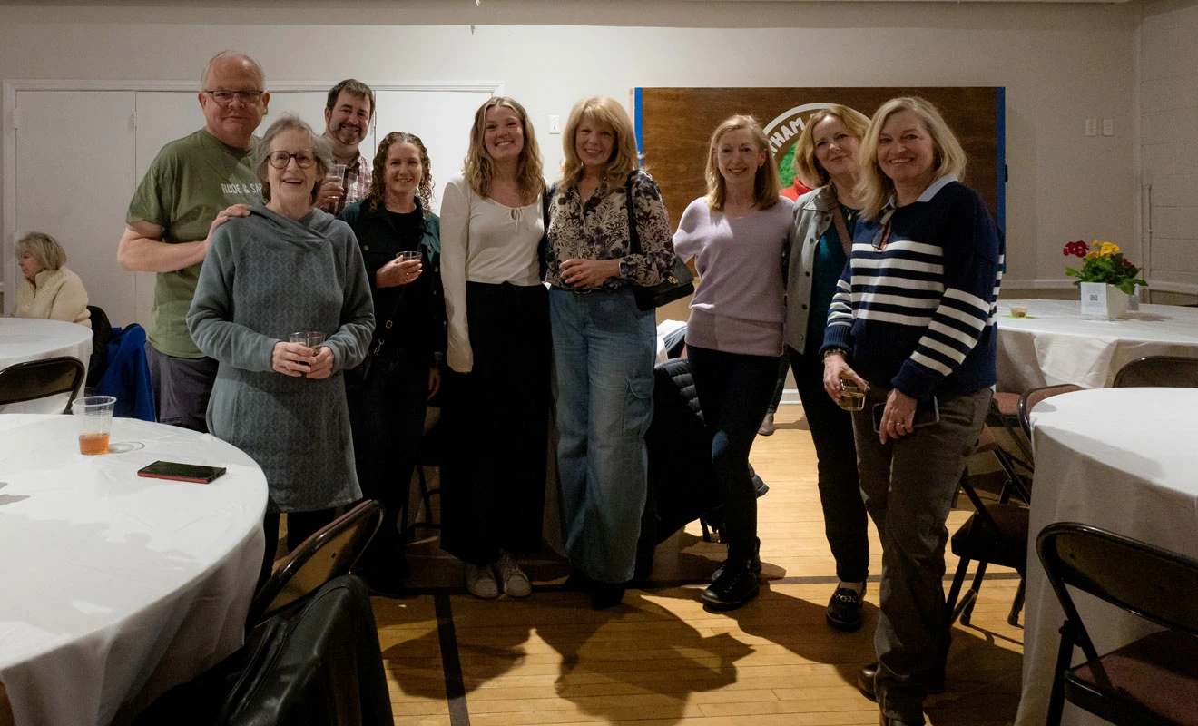 A group of women standing together in a warmly lit room.