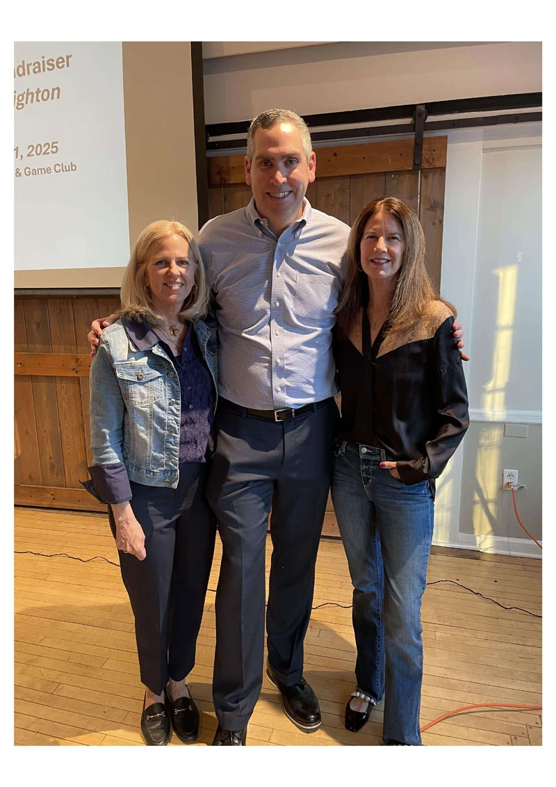 Three people posing indoors, smiling at the camera.