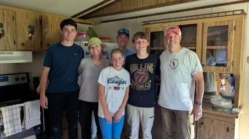 A group of six people posing together indoors, smiling.