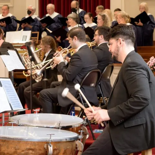 Orchestra percussionists performing with focus during a concert.
